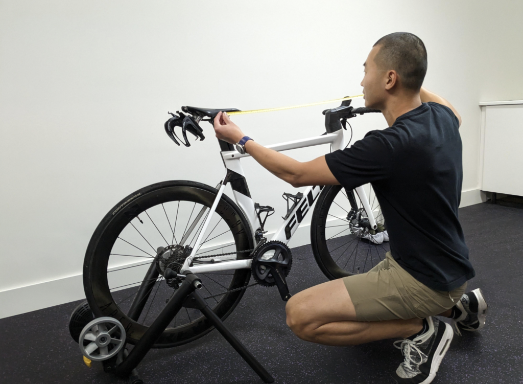 adrian doing a bike fit measurement in a physio assessment